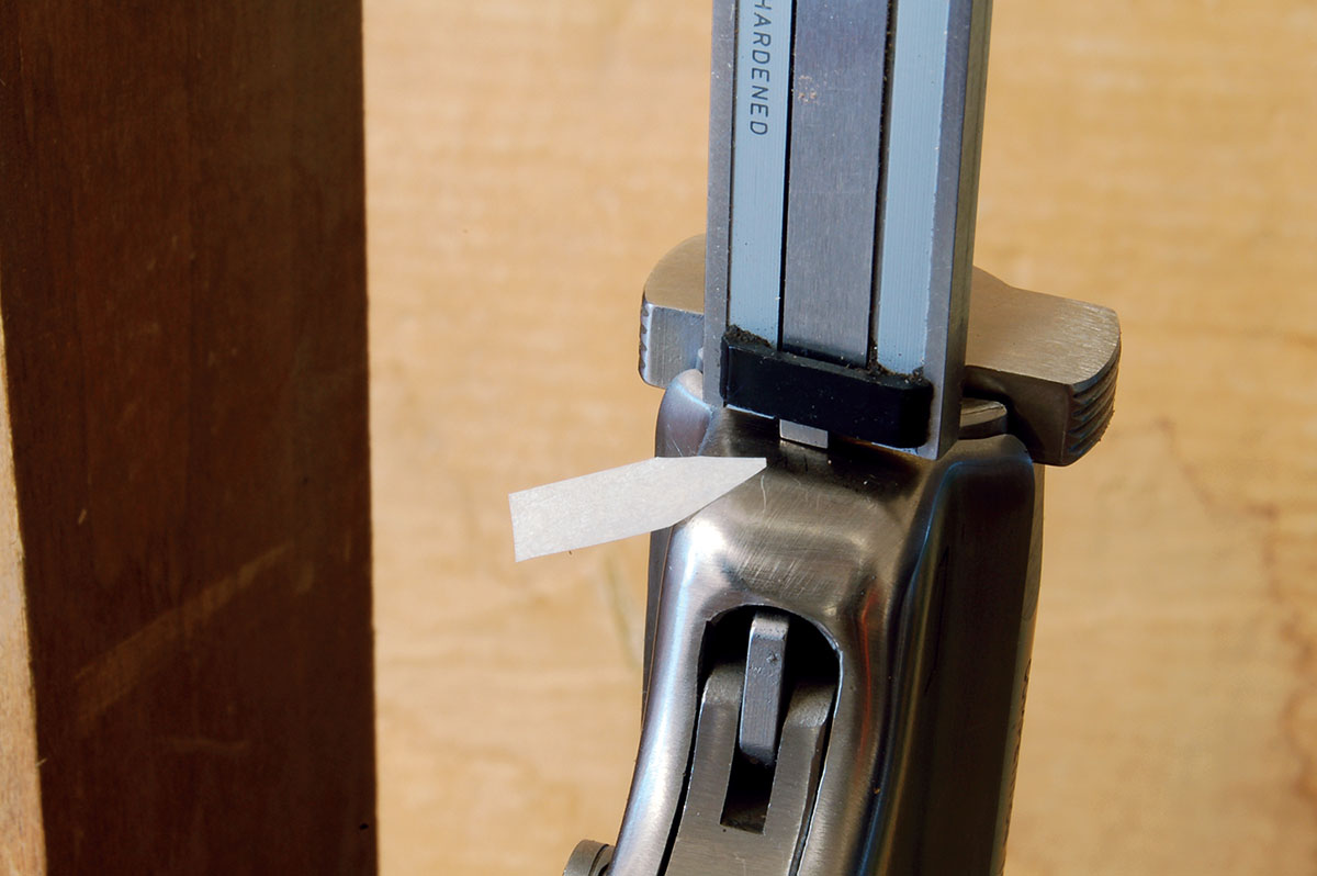 Barrel/receiver assembly protrudes past the frame some .015 to .040 inch before disassembly. This is measured with a dial caliper (arrow) and must be duplicated when the gun is reassembled.